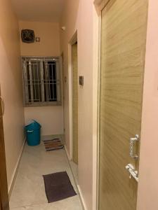 a bathroom with a shower door and a hallway at abirami arulagam in Jāmb