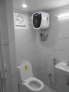 a white bathroom with a toilet and a sink at Sree jee stay in Varanasi +55 photos