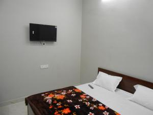 a bedroom with a bed with a flower blanket on it at Sree jee stay in Varanasi