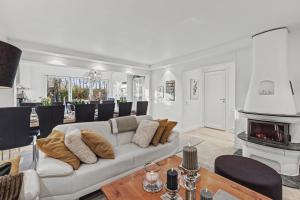a living room with a white couch and a fireplace at Hambo Stay in Staffanstorp