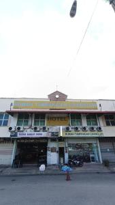 a building with a sign on the front of it at Hotel Changlun B in Bukit Kayu Hitam