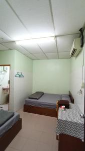 a room with two beds and a table in it at Hotel Changlun B in Bukit Kayu Hitam