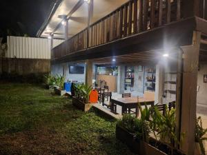 a house with a table and benches in a yard at night at Bokeo Social and Eatery in Ban Fay