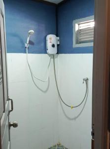 a shower in a bathroom with a hose on the wall at Bokeo Social and Eatery in Ban Fay