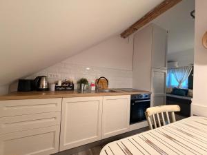 a kitchen with white cabinets and a stove at Apartment Sabljaci by the Lake in Ogulin