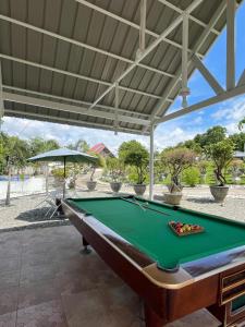 a pool table in a patio with an umbrella at Casa de Myra in Palayan City