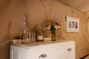 a white cabinet with a vase of flowers on it at HighlandsView in Swellendam
