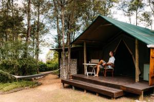 a woman sitting at a table in a black tent at HighlandsView in Swellendam