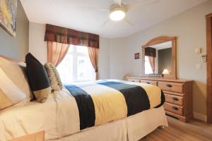 a bedroom with a bed and a dresser and a mirror at Cozy 2BR-5BD Suite - Mountain Views - Htd Parking in Canmore +17 photos