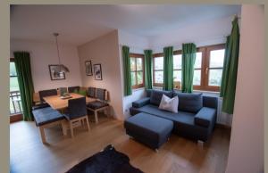 a living room with a blue couch and a table at Alpen Appartements in Embach