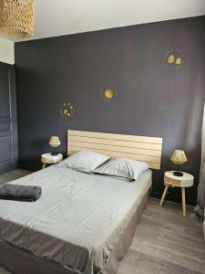 a bedroom with a large bed with two lamps on the wall at Mas des Palmiers in Grignan +34 photos
