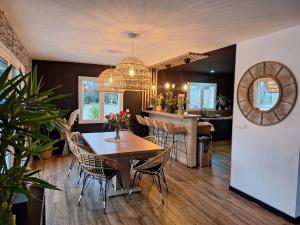 a dining room and kitchen with a table and chairs at Mas des Palmiers in Grignan