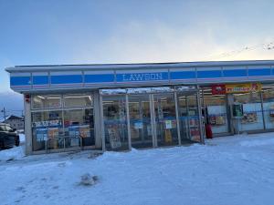 a store front with snow in front of it at Rental House Towada Yuzuriha Gallery Stay City in Towada