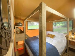 a bedroom with a canopy bed in a tiny house at Pheasant Lodge in Pangbourne