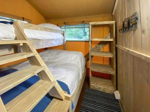 a small room with bunk beds and a bed at Pheasant Lodge in Pangbourne