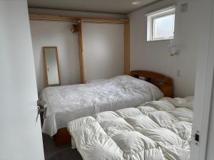 a bedroom with two beds and a window at Rental House Towada Yuzuriha Gallery Stay City in Towada