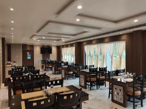 a dining room with tables and chairs in a restaurant at Aryans Sea Sight Resort Mandarmani in Mandarmoni