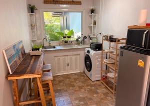 a kitchen with a sink and a washing machine at Bamboo Beach House @ Phang Nga in Thai Muang
