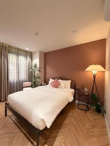 a bedroom with a large white bed and a lamp at Tiny House Phu Quoc in Phú Quốc