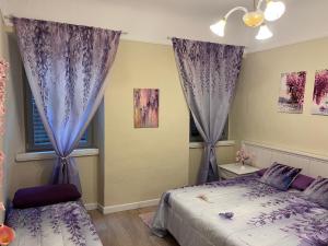 a bedroom with purple curtains and a bed at Agapanthus in Offida