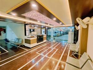 a living room with wooden floors and a large window at Hotel Laxmi villa in Naini