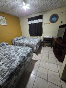 a hotel room with two beds and a ceiling fan at EL MIRADOR dlr HR in Quetzaltenango