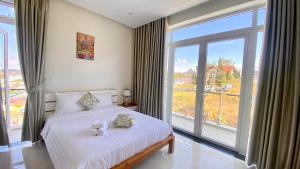 a bedroom with a bed and a large window at Lộc Phú Villa - Hoanglee in Da Lat