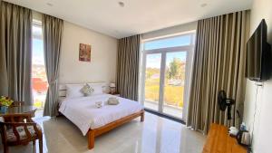 a bedroom with a bed and a large window at Lộc Phú Villa - Hoanglee in Da Lat