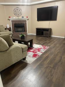 a living room with a couch and a television on a wall at Kindness Dwells in Killeen