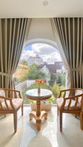 a room with two chairs and a table and a large window at Lộc Phú Villa - Hoanglee in Da Lat
