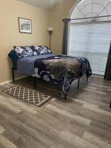 a bedroom with a bed with a blue blanket and a window at Kindness Dwells in Killeen
