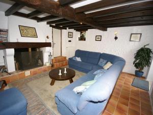 a living room with a blue couch and a fireplace at Spacious holiday home with pool in Lusignac in Bouteilles-Saint-Sébastien