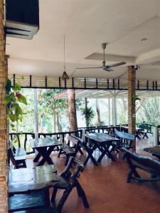 a group of tables and benches in a room at Saiyok River House in Sai Yok