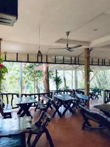 a restaurant with tables and chairs in a room at Saiyok River House in Sai Yok
