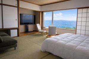 a bedroom with a large bed and a view of the ocean at 天海の城 in Saikai
