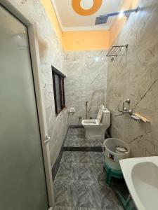 a bathroom with a white toilet and a sink at Himalayan Stayz in Rishīkesh