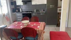 a kitchen with a table with red chairs and a red table cloth at Chioselle in Chiatra +11 photos