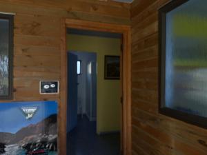 a hallway with a door to a room with a television at Freestone off-grid cabin in Manapouri