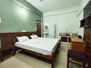 a bedroom with a large white bed in a room at Staysafe in Kattakkada