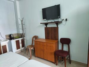 a bedroom with a tv and a bed and a chair at Staysafe in Kattakkada
