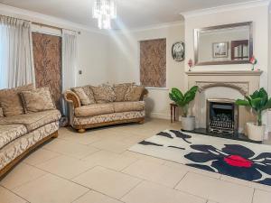 a living room with two couches and a fireplace at Gokula House in Cockermouth