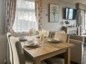 a wooden table with chairs and a dining room at Bluebell Lodge - Uk51382 in Wigton