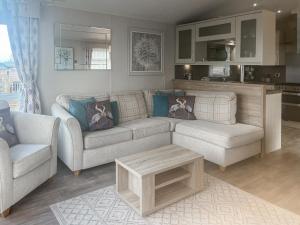 a living room with a couch and a table at Bluebell Lodge - Uk51382 in Wigton