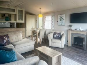 a living room with a couch and a fireplace at Bluebell Lodge - Uk51382 in Wigton