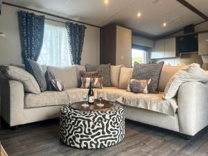 a living room with two couches and a table at Herdwick Lodge - Uk51383 in Westward
