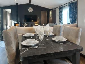 a dining room with a table with plates and wine glasses at Herdwick Lodge - Uk51383 in Westward