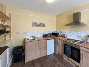 a kitchen with a sink and a stove top oven at Albert Cottage in Llandudno