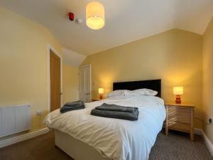 a bedroom with a bed with two towels on it at Albert Cottage in Llandudno