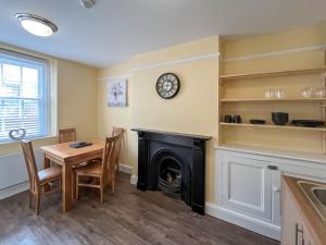 a dining room with a table and a fireplace at Albert Cottage in Llandudno +4 photos