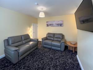 a living room with two chairs and a table at Albert Cottage in Llandudno